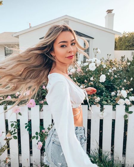 Sierra Furtado in a white top poses for a picture in her garden.